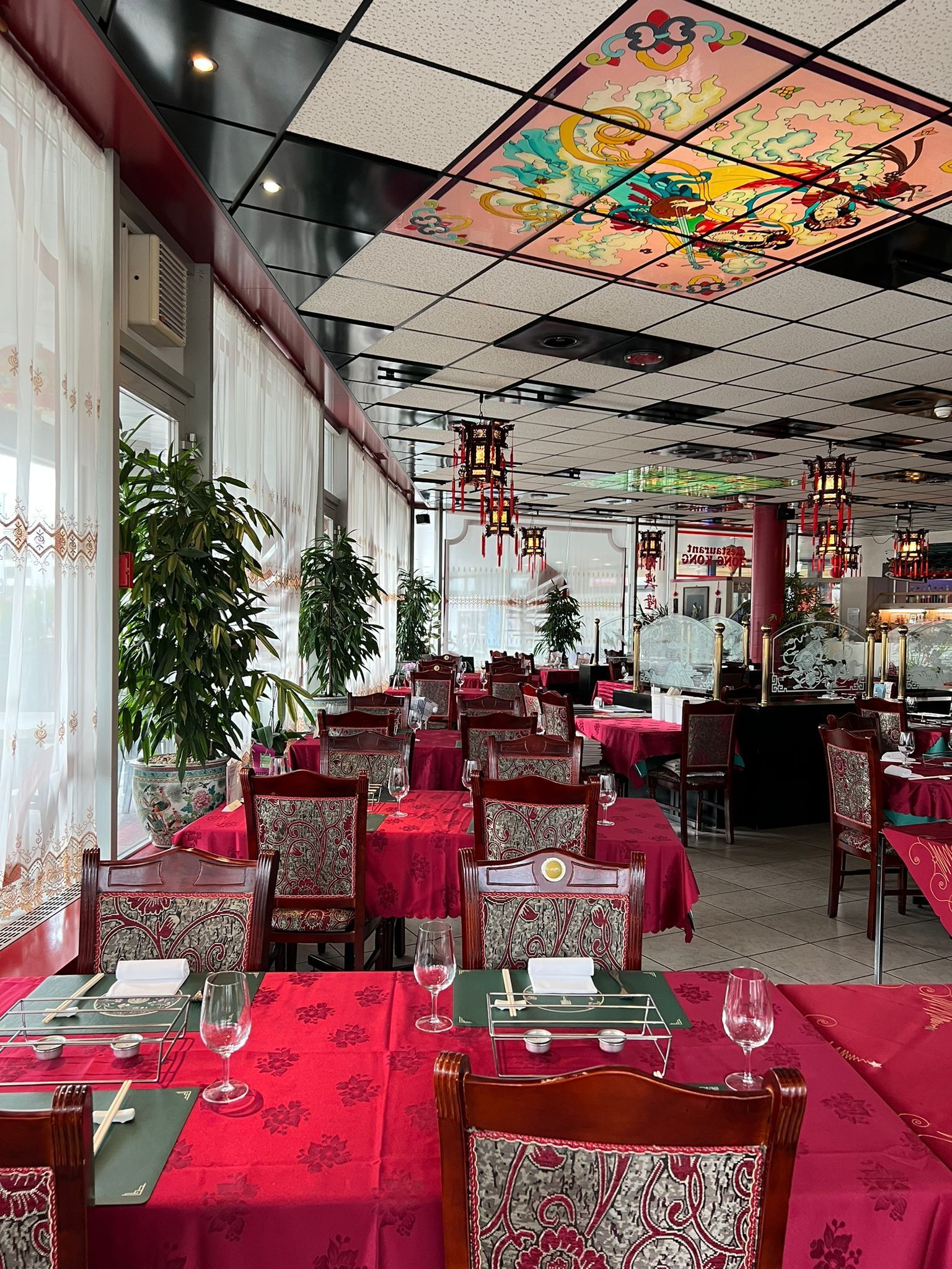 Ein großes Esszimmer mit Tischen und Stühlen und einer bunten Decke.