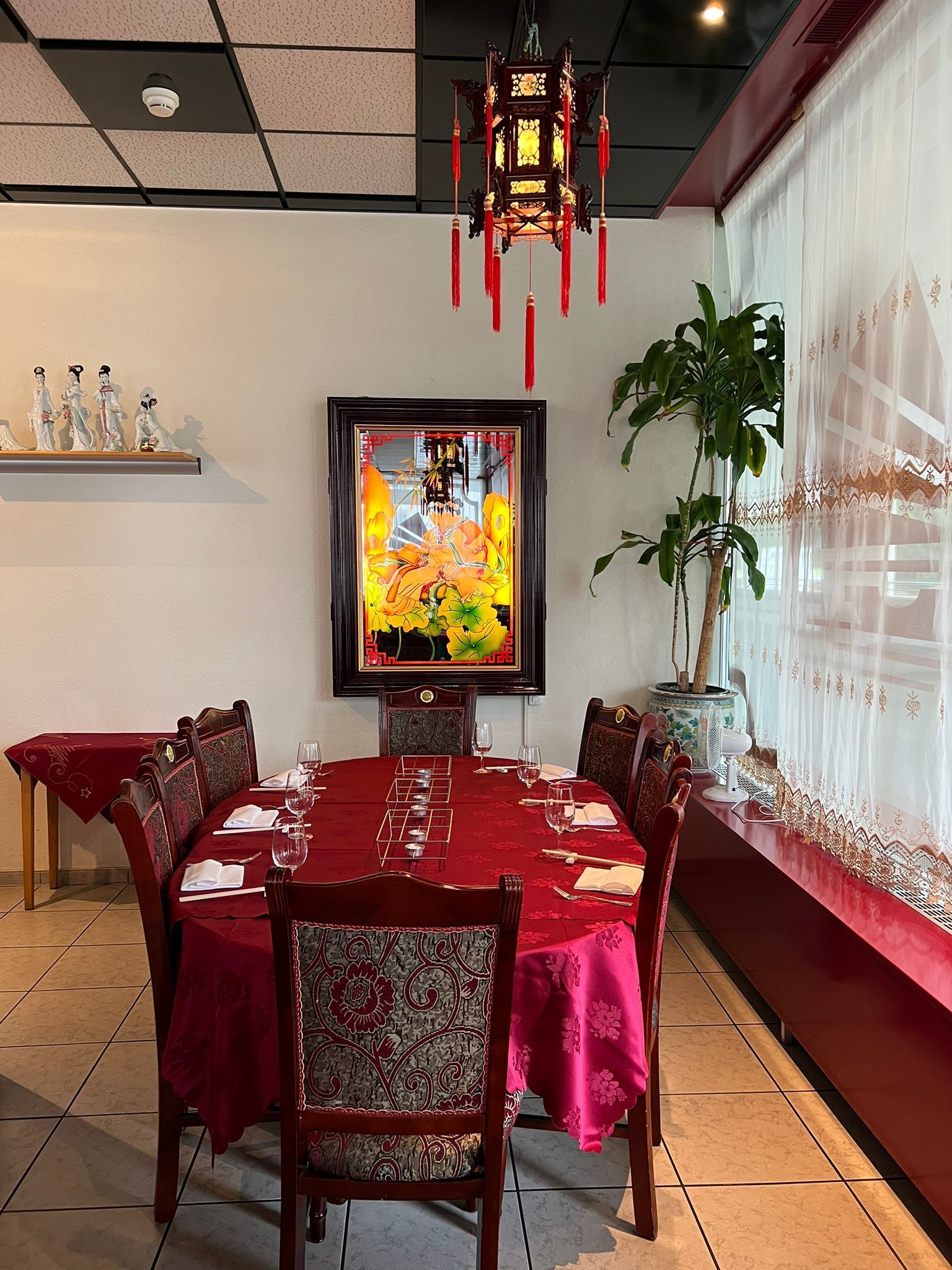 Ein Esszimmer mit einem langen Tisch und Stühlen und einem Bild an der Wand.