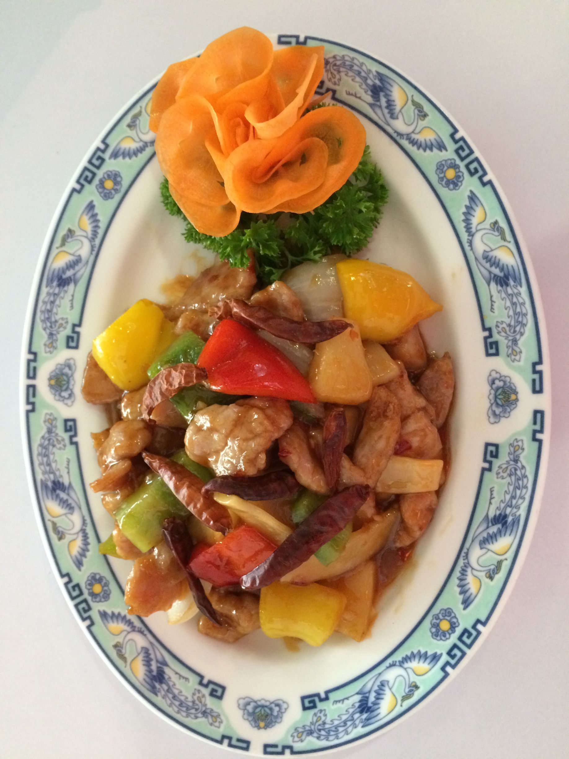 Ein Teller mit Essen, Gemüse und einer Blume darauf