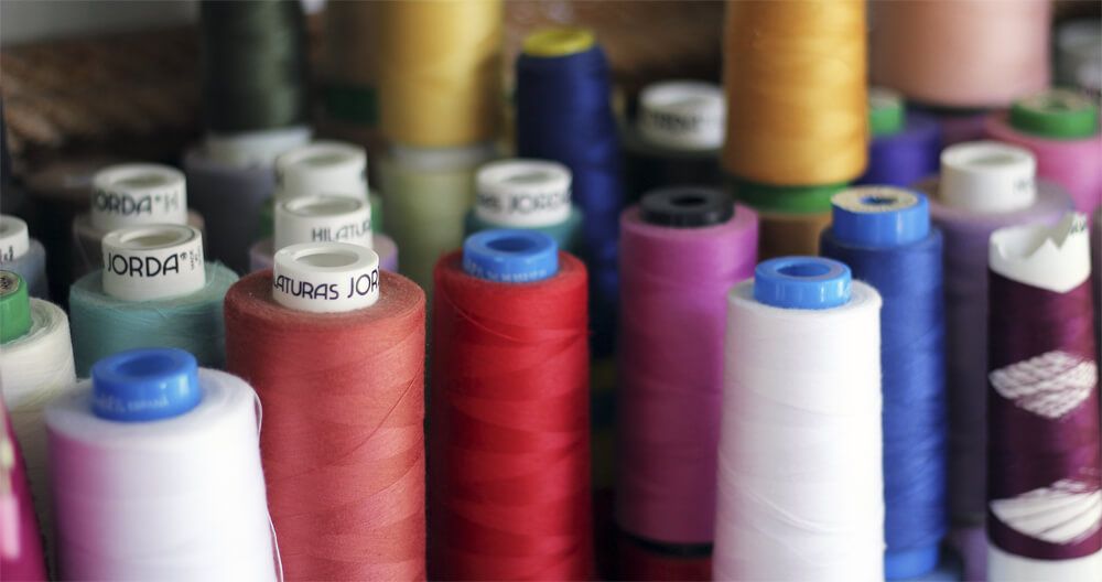 Un montón de carretes de hilo están sobre una mesa.