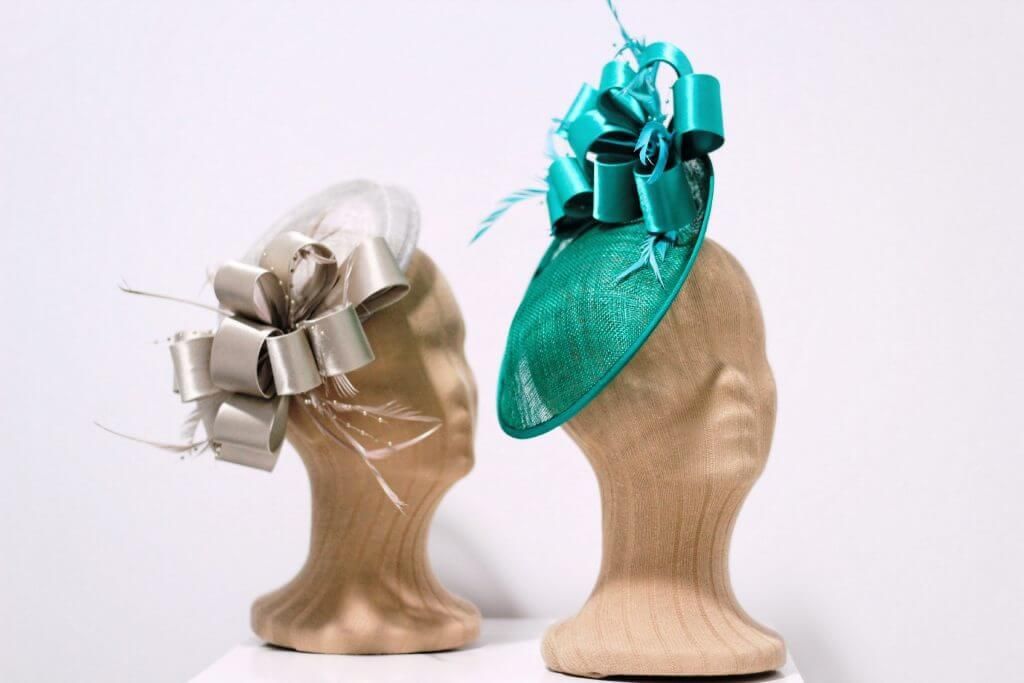 Dos maniquíes con sombreros están sentados uno al lado del otro en una mesa.