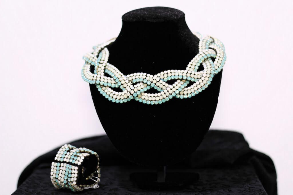 Un collar y una pulsera están en un maniquí negro.