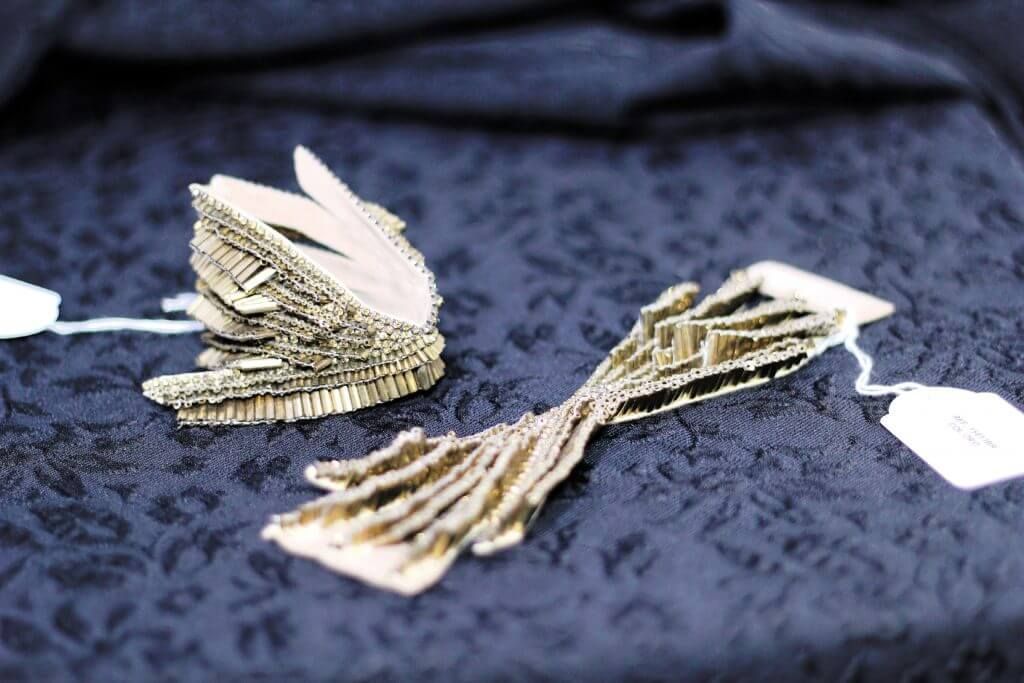 Un par de pendientes están sobre un paño azul.