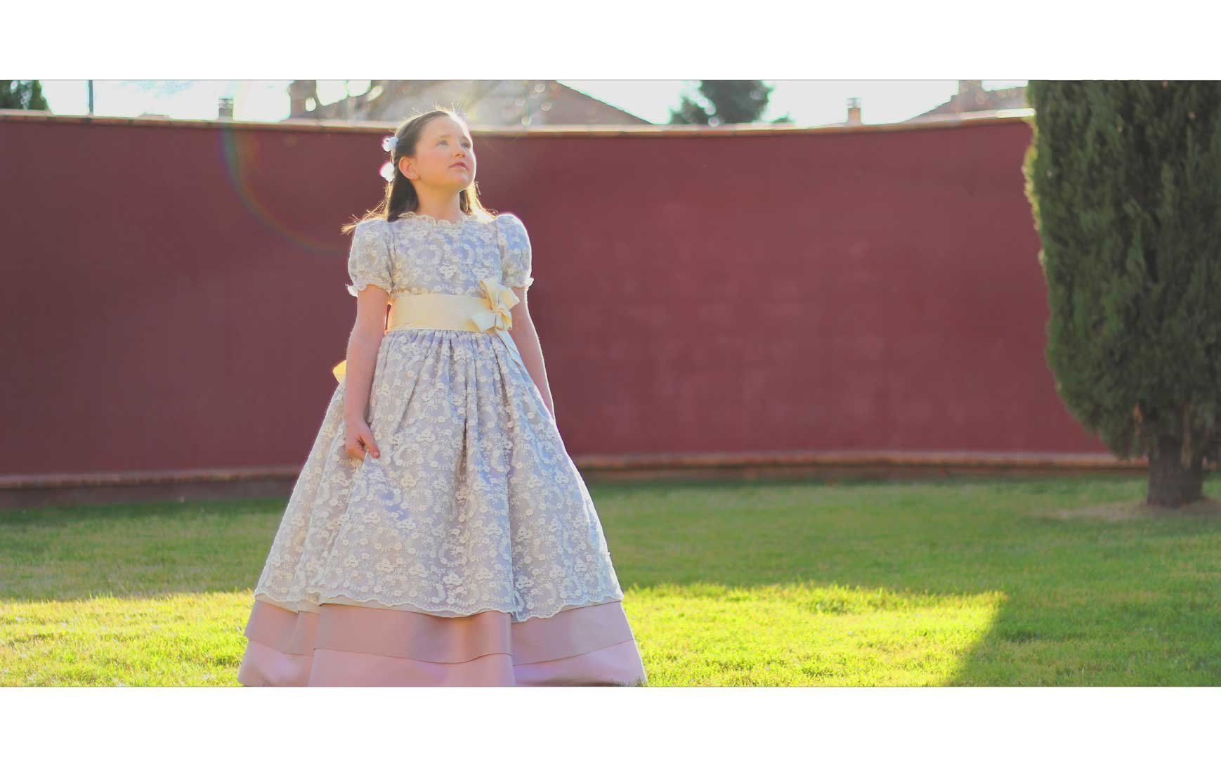 Una niña con un vestido está parada en un campo de hierba.