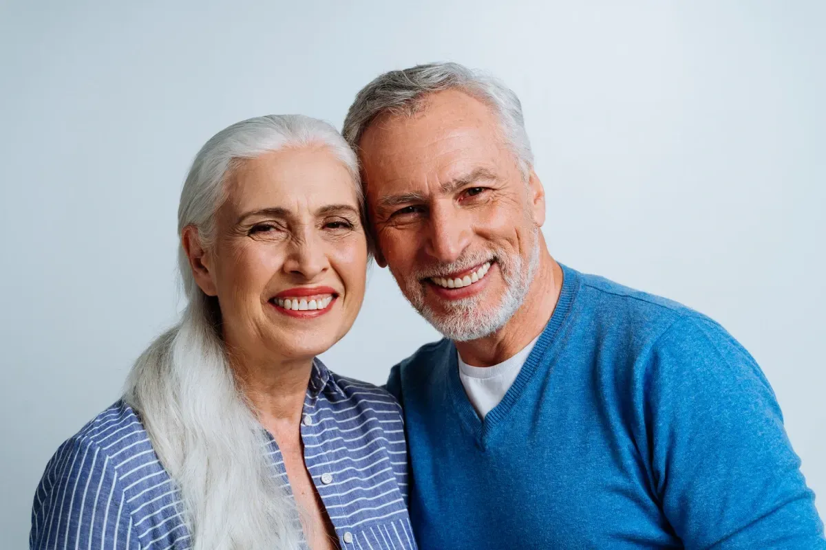 Un hombre y una mujer posan para una fotografía juntos y sonriendo.