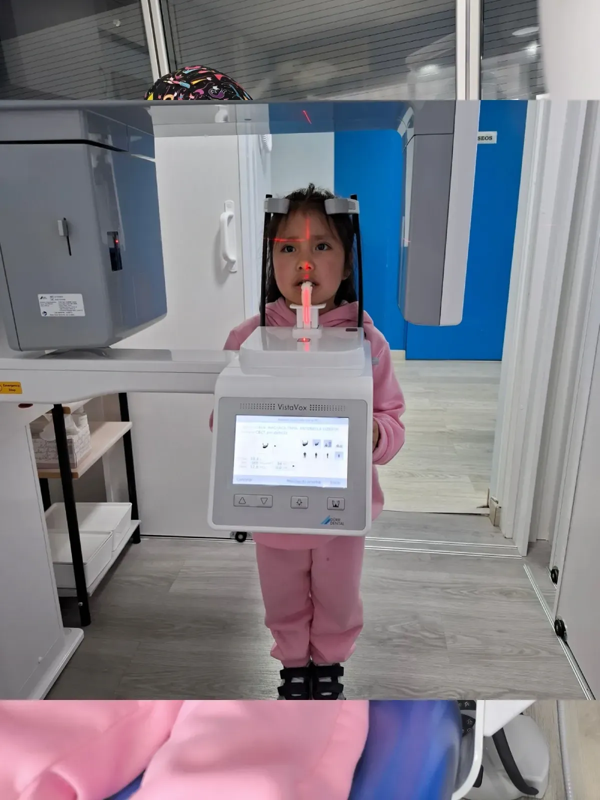 Una niña está parada frente a una máquina dental.