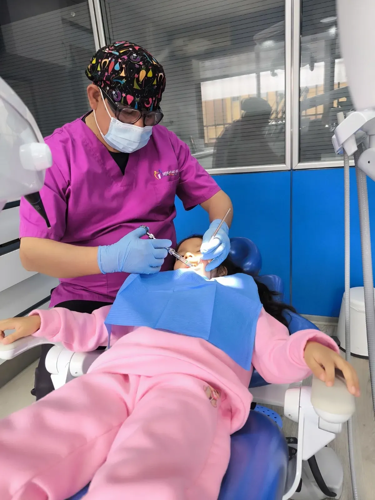 Una niña pequeña se está haciendo examinar los dientes por un dentista.