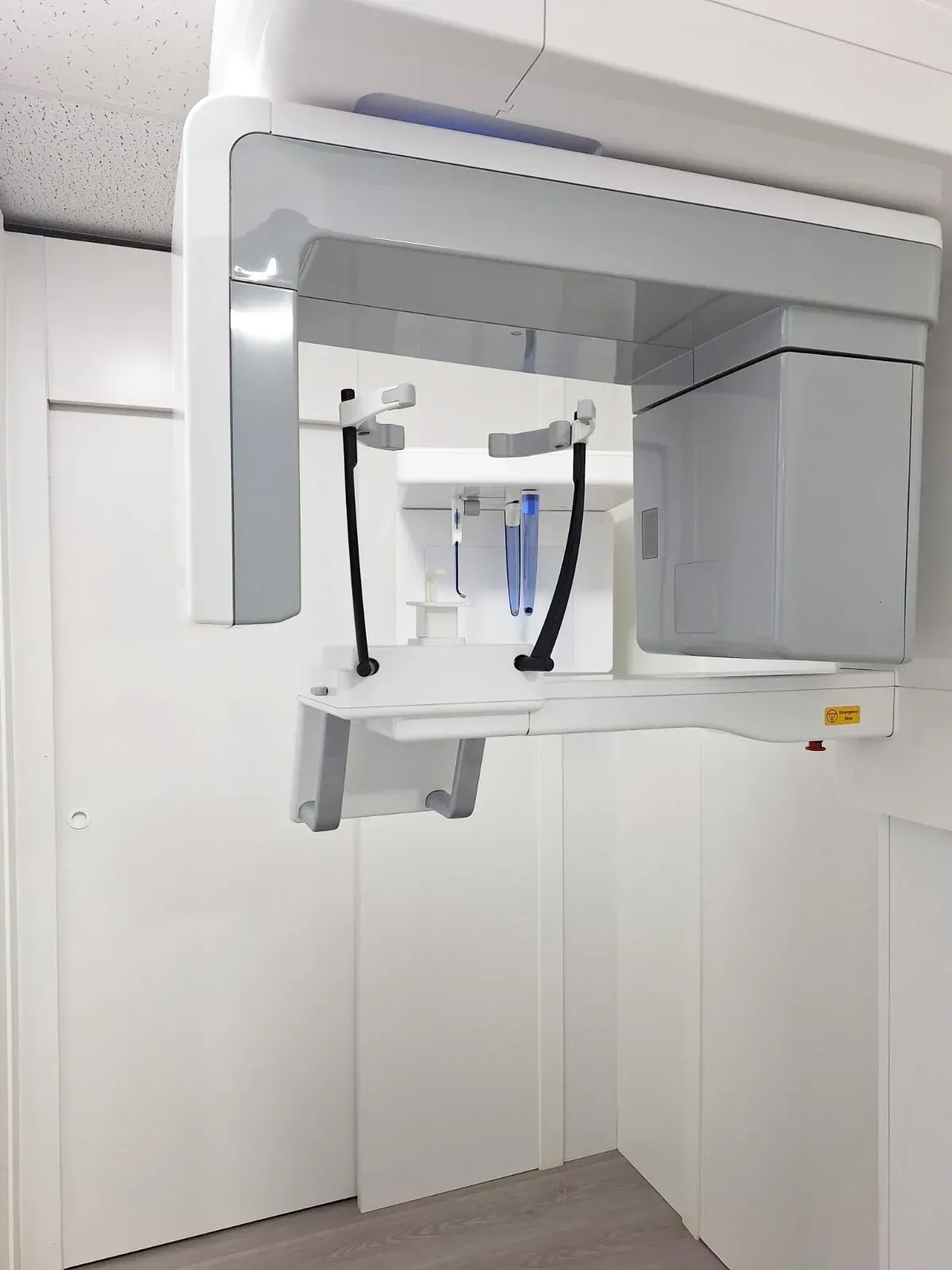 Una máquina de rayos X dental está colgada del techo de una habitación.