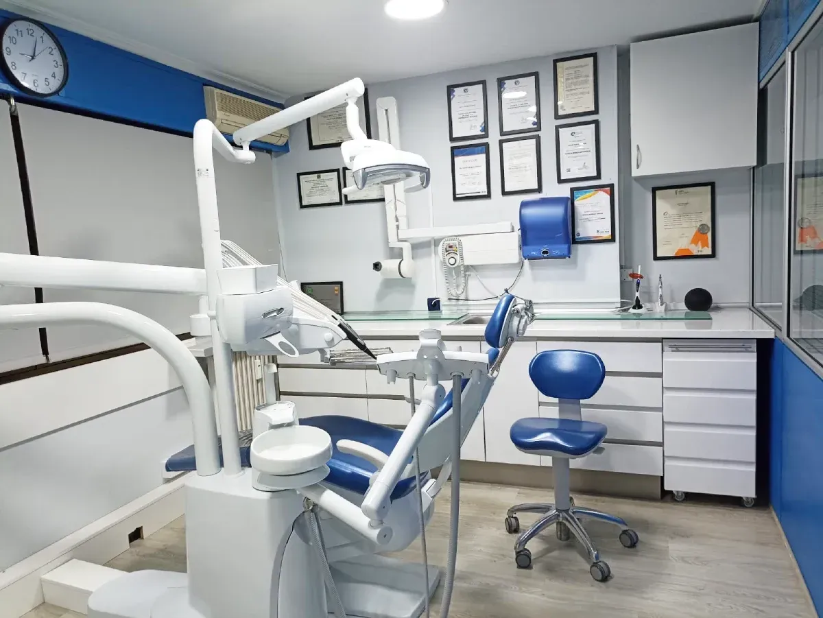Un consultorio dental con un sillón dental y un reloj en la pared.