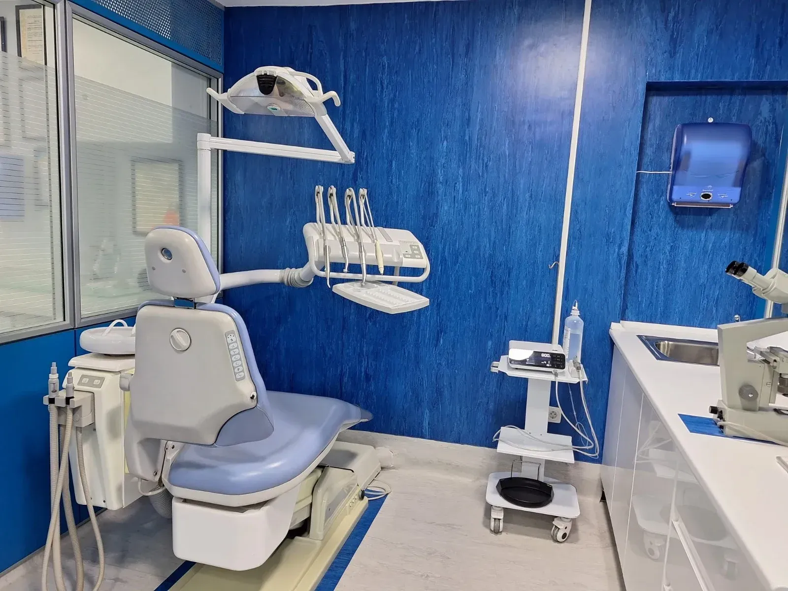 Un consultorio dental con un microscopio y un sillón dental