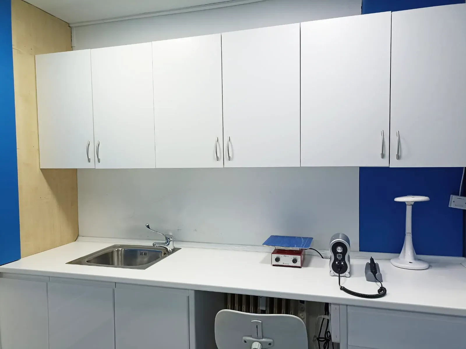 Una cocina con gabinetes blancos y un fregadero.