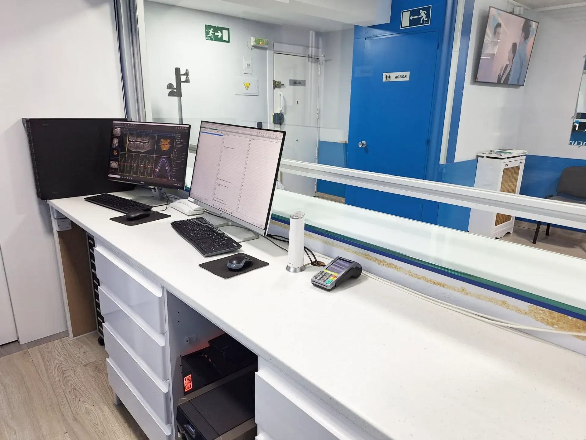 Una computadora está sobre un escritorio frente a una ventana.