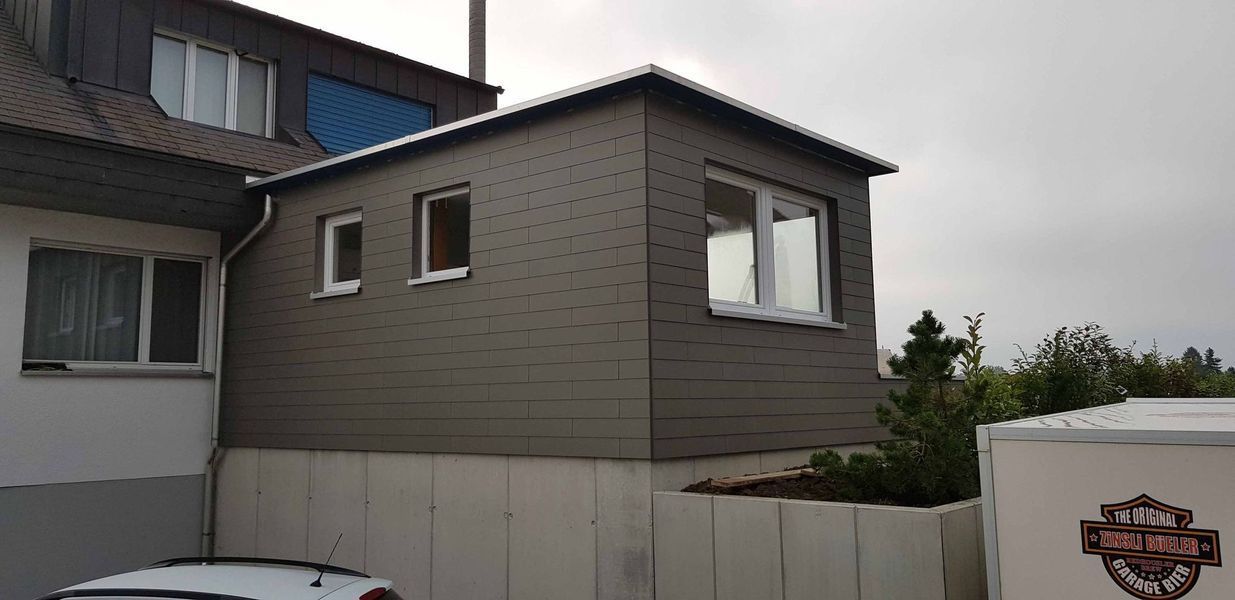 Ein modernes Haus mit schwarzer Fassade. Foto von der Mannhart Holzbau AG