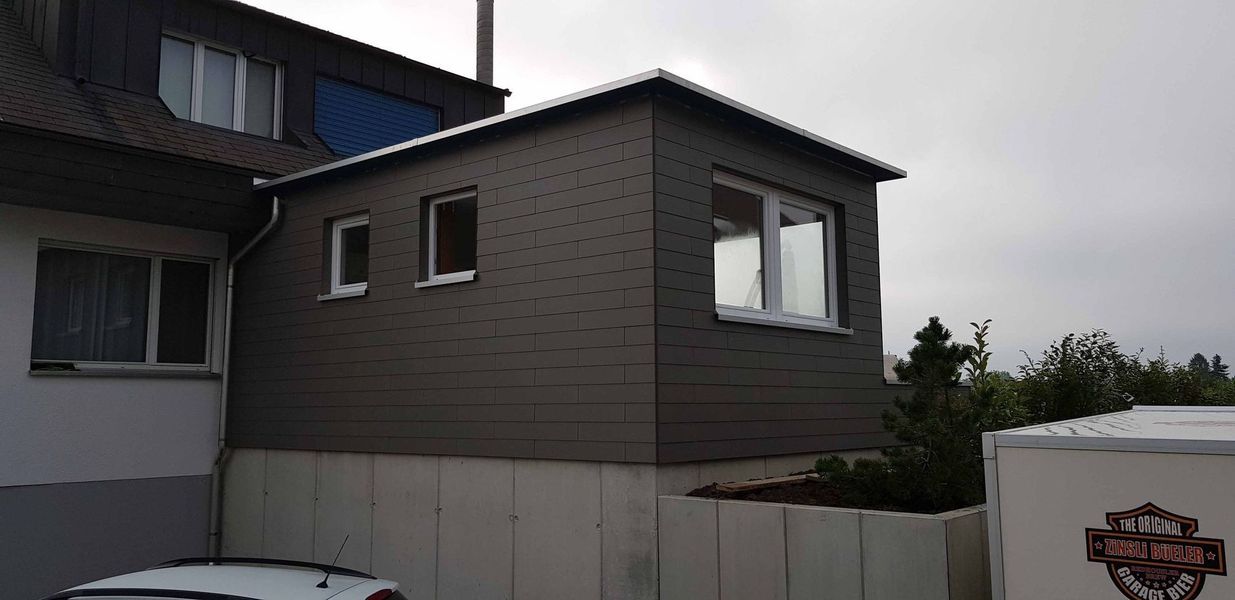 Ein Haus mit vielen Fenstern und einem Balkon. Foto von der Mannhart Holzbau AG 