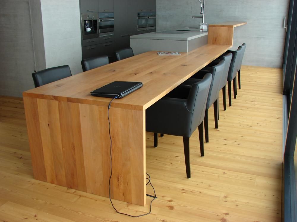 Ein langer Holztisch mit Stühlen und einem Laptop darauf. Foto von der Mannhart Holzbau AG