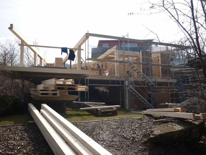 Ein Haus wird mit Holzbalken und Gerüsten gebaut