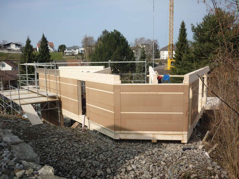 Ein im Bau befindliches Gebäude mit einem Kran im Hintergrund. Foto von der Mannhart Holzbau AG