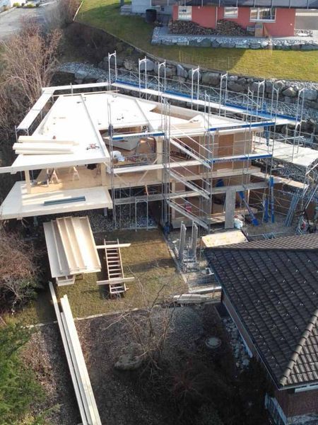 Eine Luftaufnahme eines im Bau befindlichen Hauses, das von einem Gerüst umgeben ist.