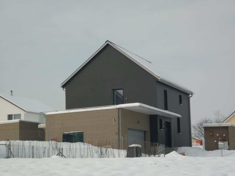 Ein Haus mit Garage ist von Schnee umgeben