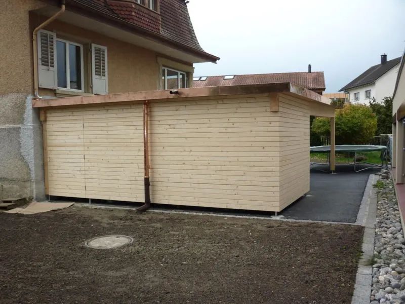 Im Hinterhof eines Hauses wird ein Holzcarport gebaut. Foto von der Mannhart Holzbau AG