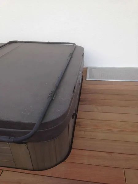 Auf einem Holzdeck steht ein Whirlpool.