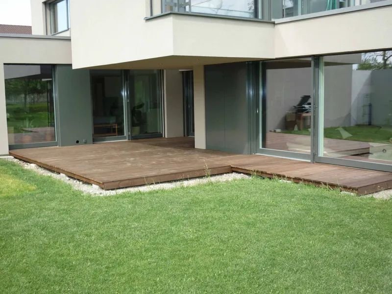 Ein großes Haus mit einer Holzterrasse davor