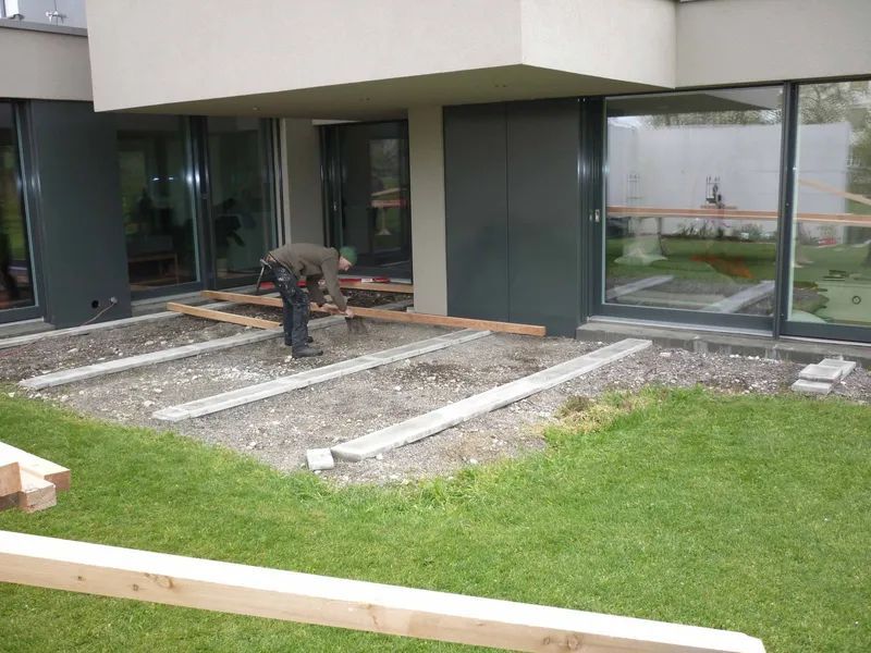 Ein Mann arbeitet auf einem Deck vor einem Gebäude