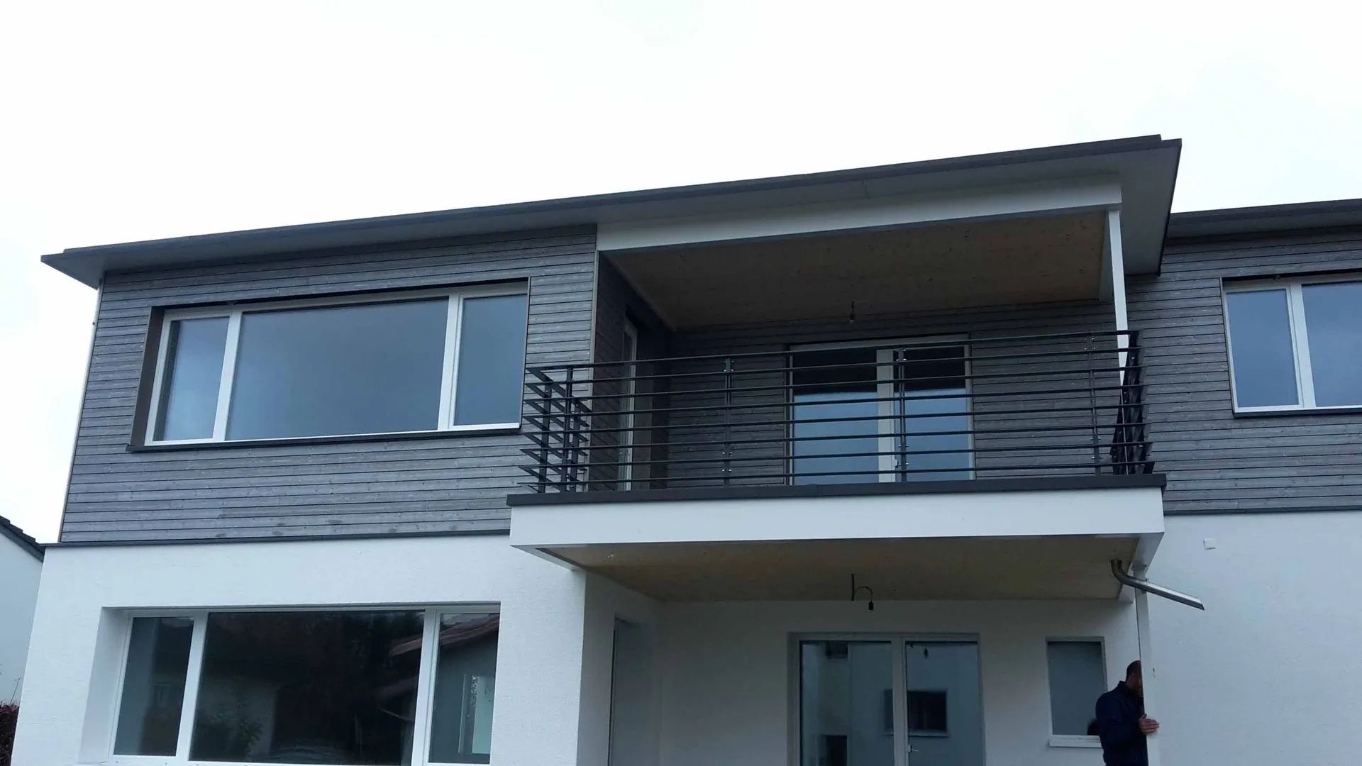 Ein grosses Haus mit Balkon und vielen Fenstern. Foto von der Mannhart Holzbau AG