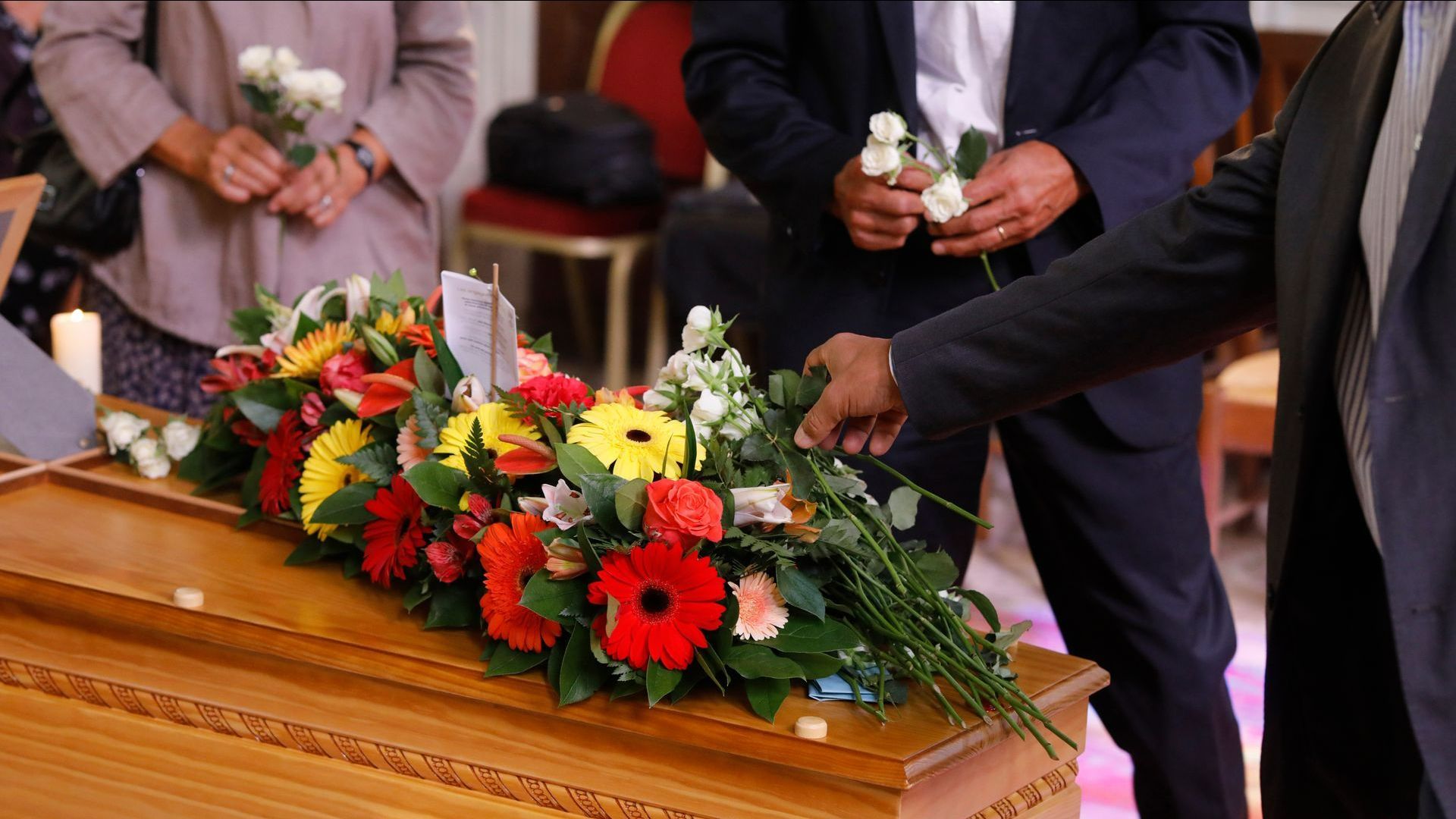 Pose de fleurs sur un cercueil