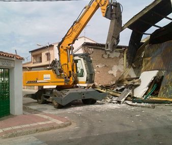 Una excavadora Liebherr amarilla está demoliendo un edificio
