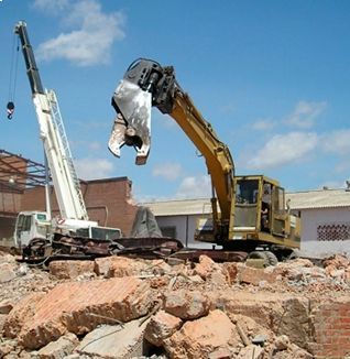 Una excavadora amarilla está trabajando en una pila de rocas.
