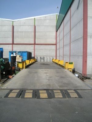 Un almacén con una gran báscula delante.