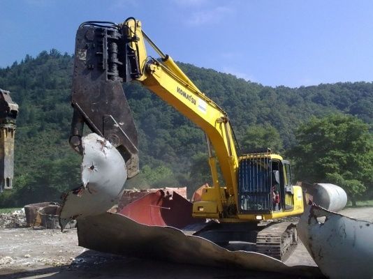 Un hombre está soldando un objeto grande de donde salen chispas.