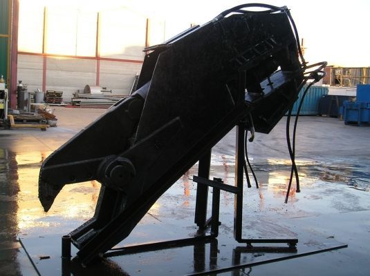 Un gran objeto negro está sobre un soporte en un estacionamiento.