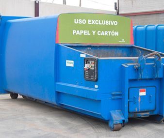 Un contenedor azul con un cartel verde que dice 
