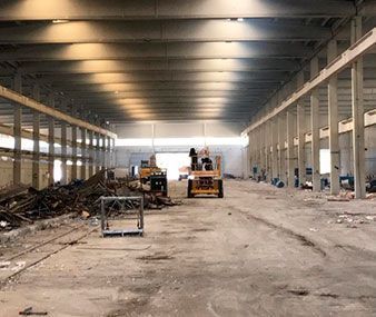 Un gran almacén vacío con mucha maquinaria en su interior.