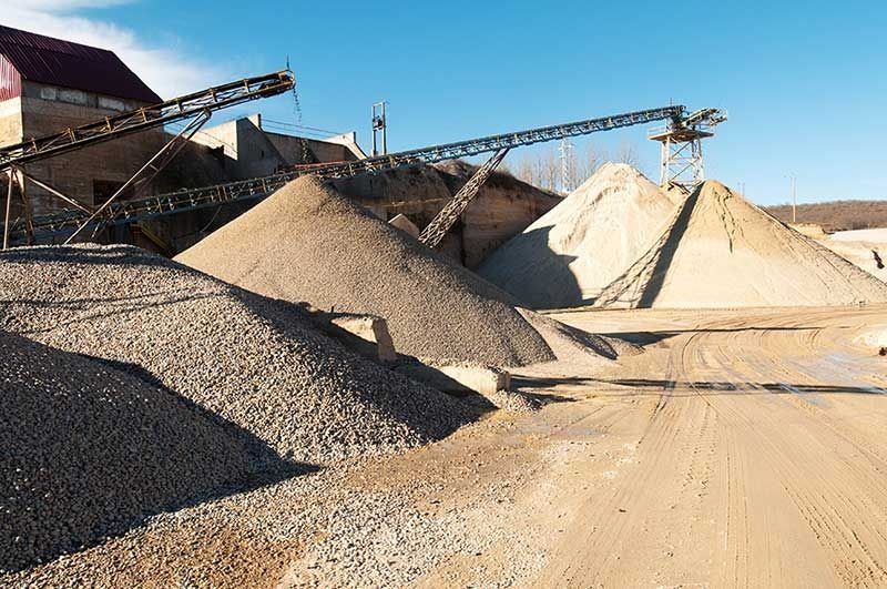 Un montón de grava se encuentra encima de un camino de tierra.