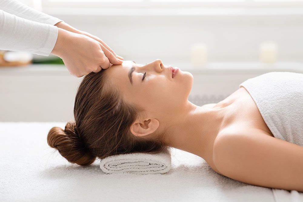 Eine Frau bekommt in einem Spa eine Kopfmassage.