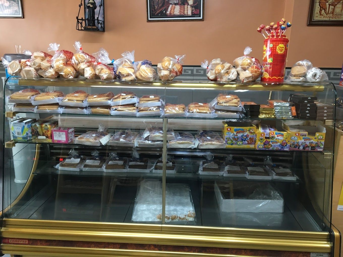 Una vitrina de panadería llena de mucho pan y pasteles.