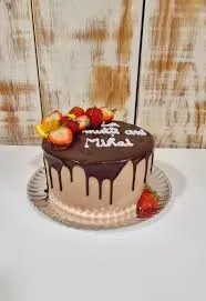 Un pastel de chocolate con fresas encima está sentado en un plato sobre una mesa.