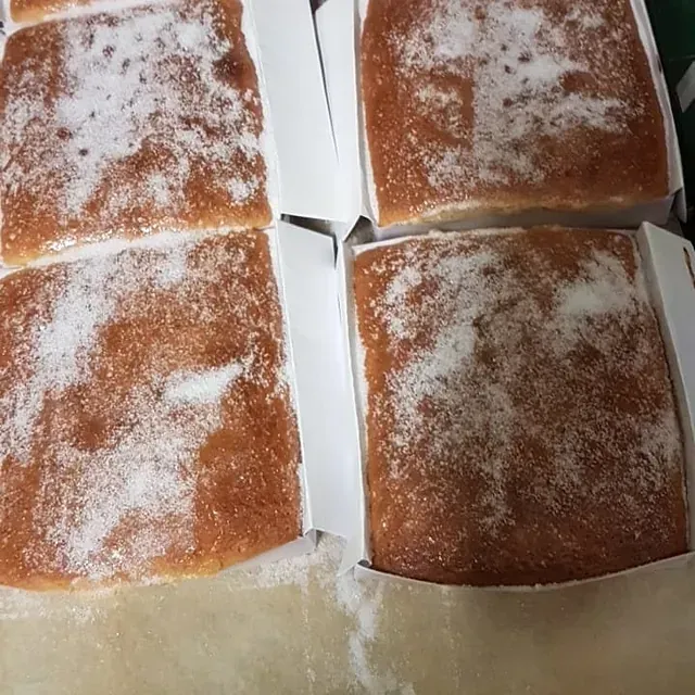 Una caja de pasteles con azúcar en polvo encima