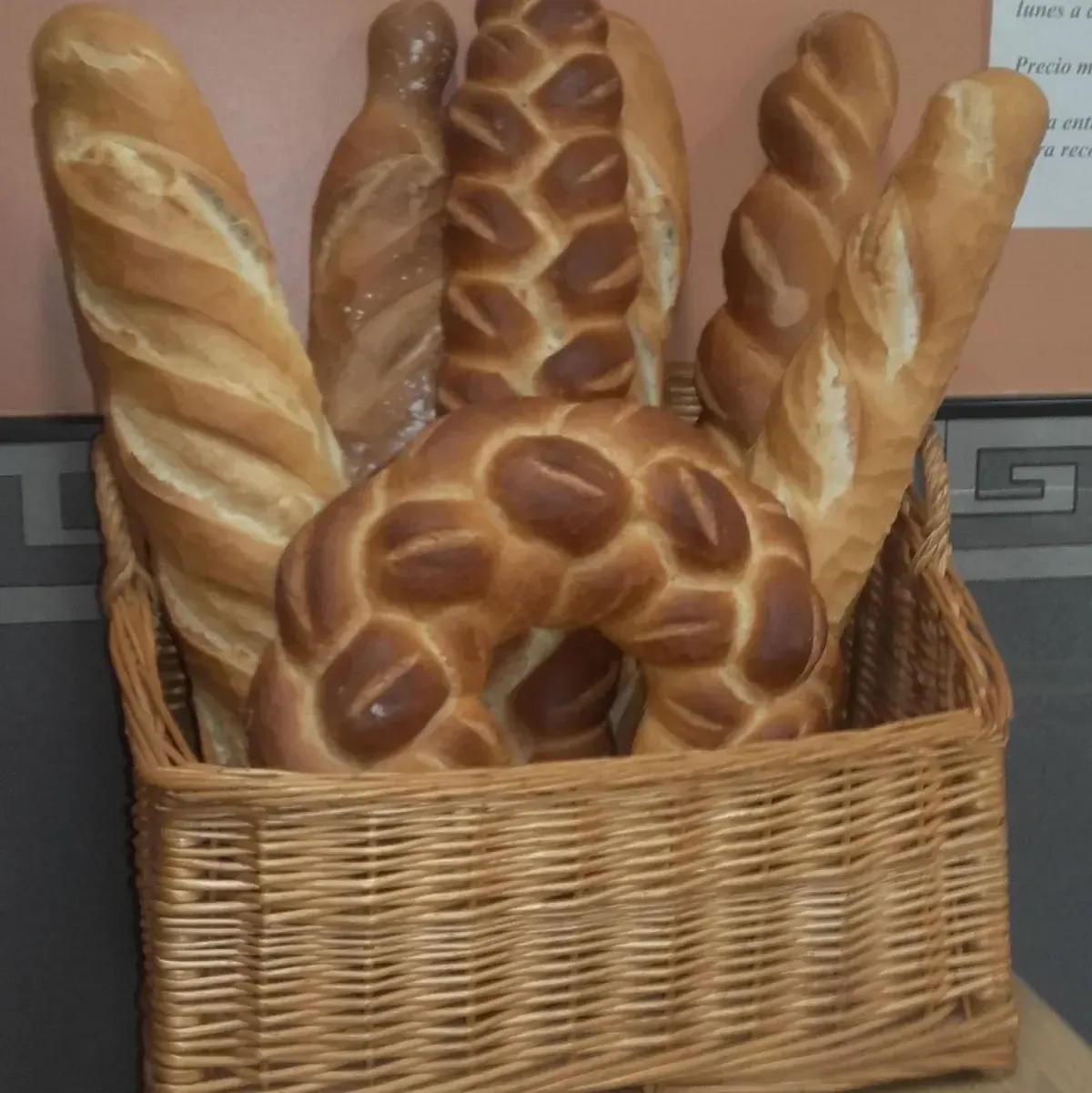 Una cesta de mimbre llena de diferentes tipos de pan