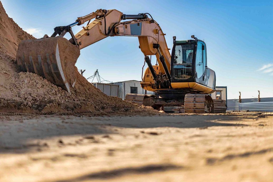Una excavadora está cavando un hoyo en el suelo en un sitio de construcción.