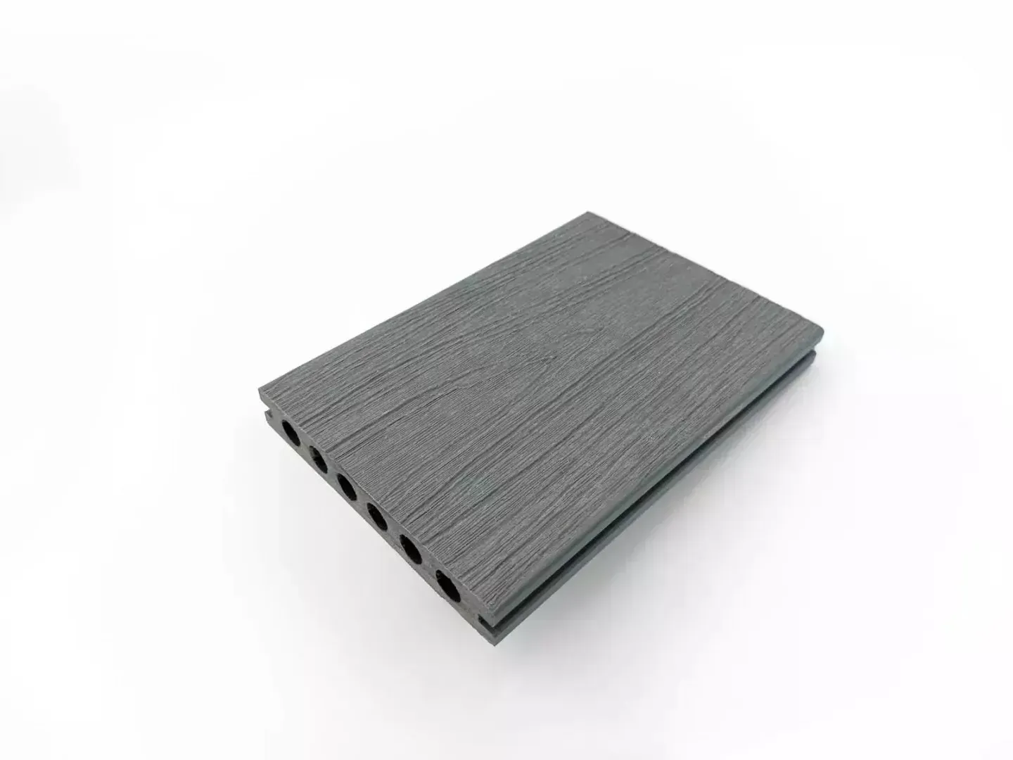 Tabla de tarima compuesta gris ranurada con canales laterales huecos, aislada sobre fondo blanco.