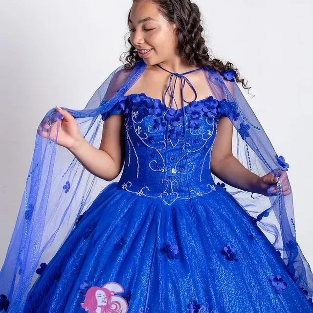 Una mujer con un vestido azul y una capa