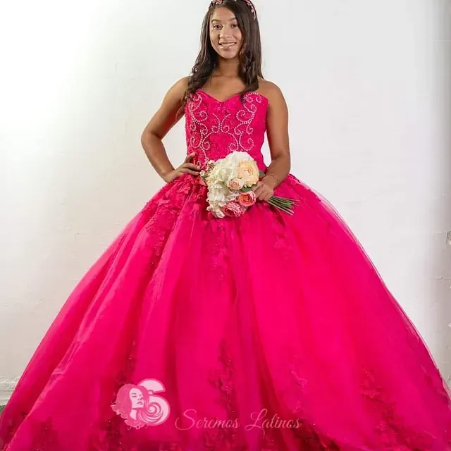 Una mujer con un vestido rosa sostiene un ramo de flores.