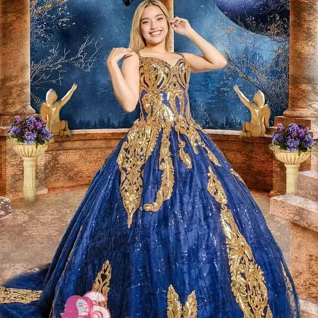 Una mujer con un vestido azul y dorado posa para una fotografía.