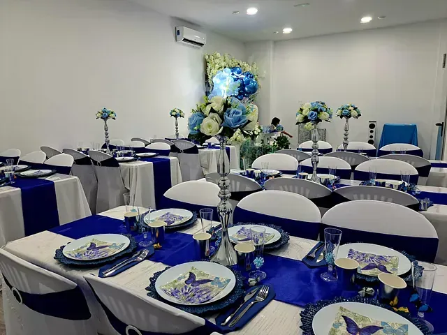 Una sala con mesas y sillas preparadas para una recepción de boda.