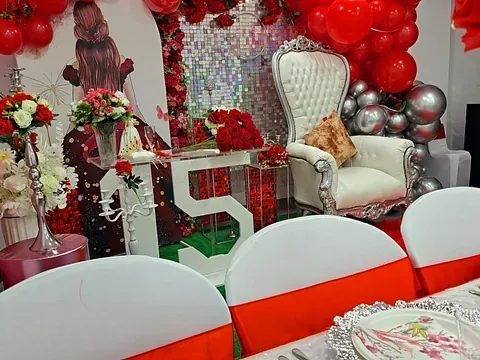 Una habitación decorada con globos rojos y flores para una fiesta de cumpleaños.