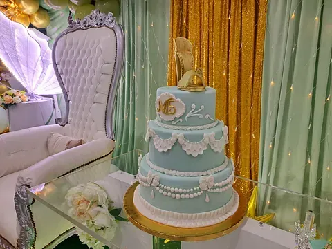 Un pastel de tres niveles está colocado encima de una mesa de cristal.
